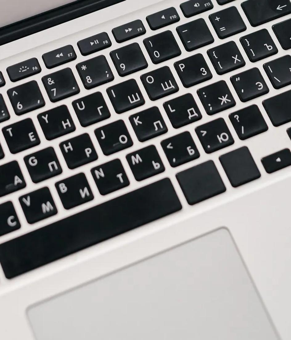 A laptop showing performance graphs on a desk beside printed reports, the same period counted twice by two sources