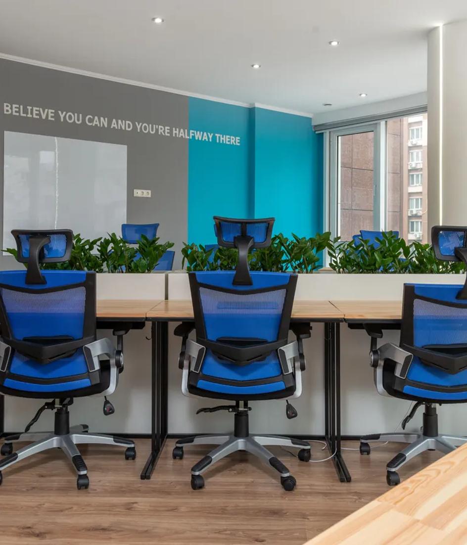 An empty boardroom with a long wooden table and chairs set for a meeting, the room where a brand budget is approved or refused.