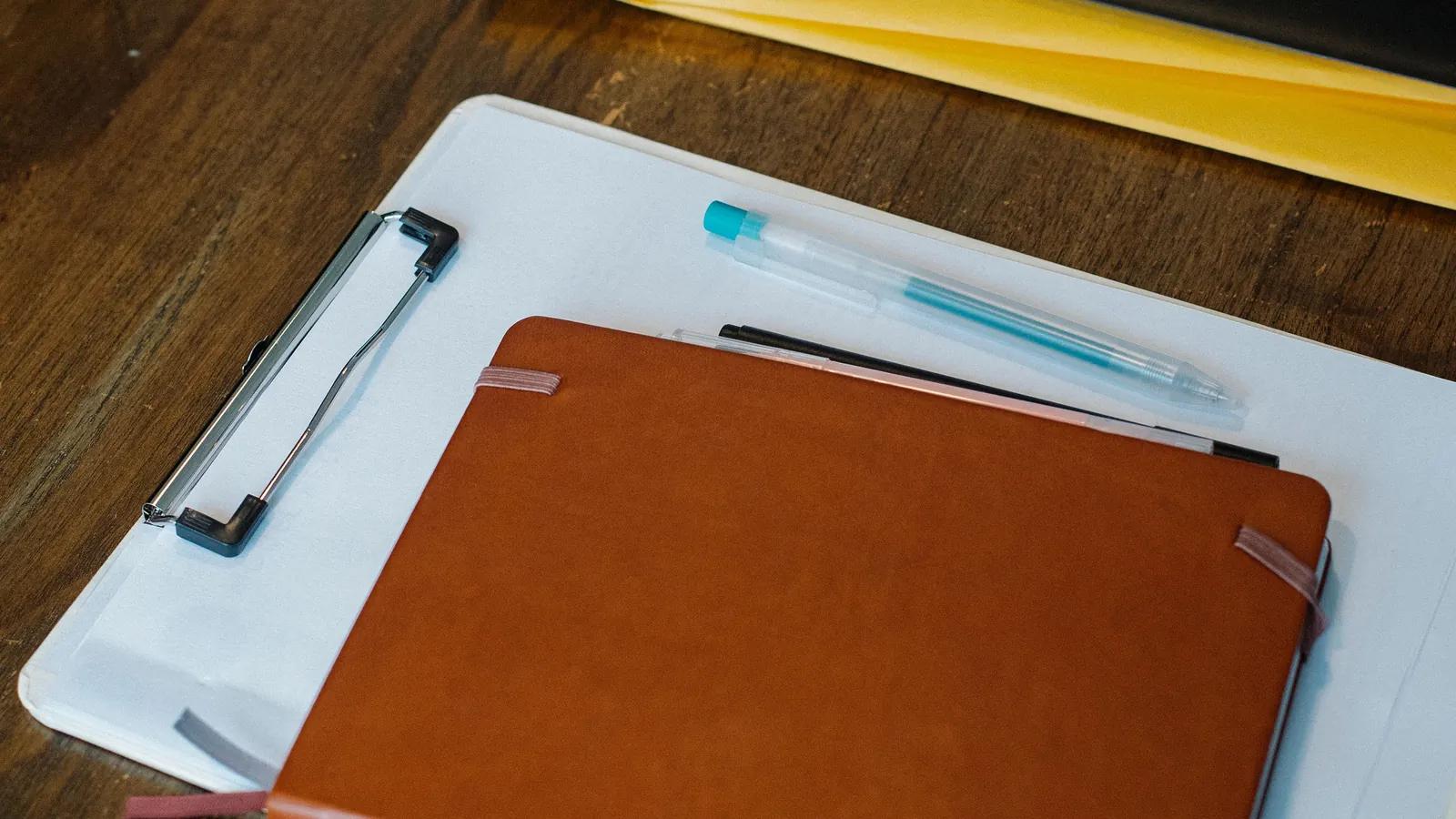 Clipboard, folders and papers arranged on a desk, the paper equivalent of an append-only record of what changed and on what input