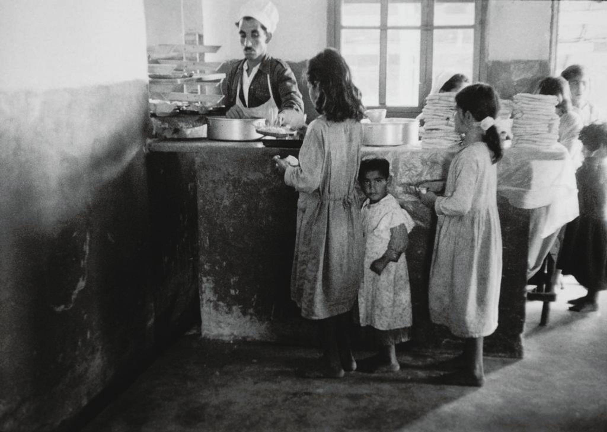 Children in line to get food in a canteen.