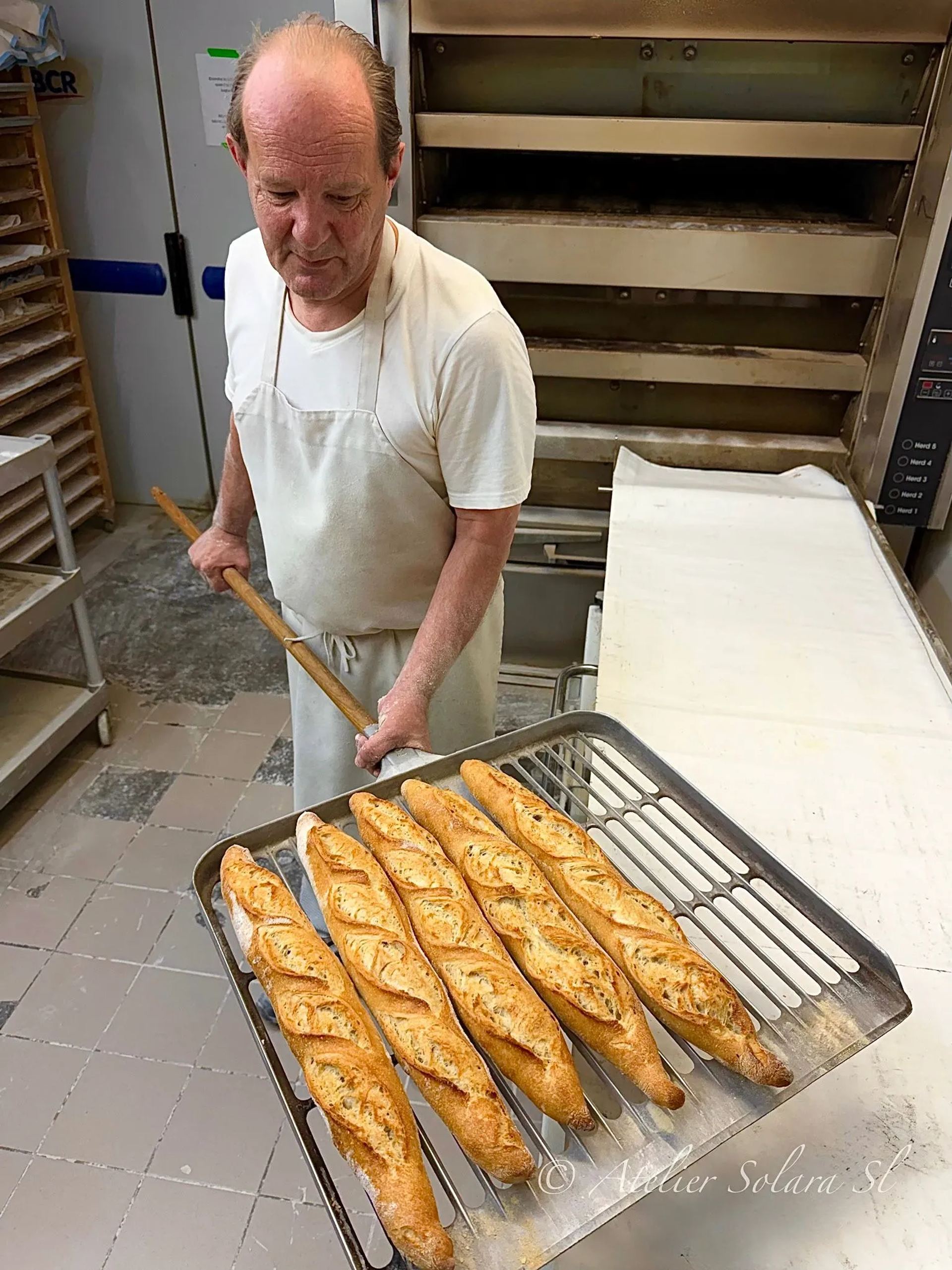 Thierry Goupil sort une plaque de baguettes du four
