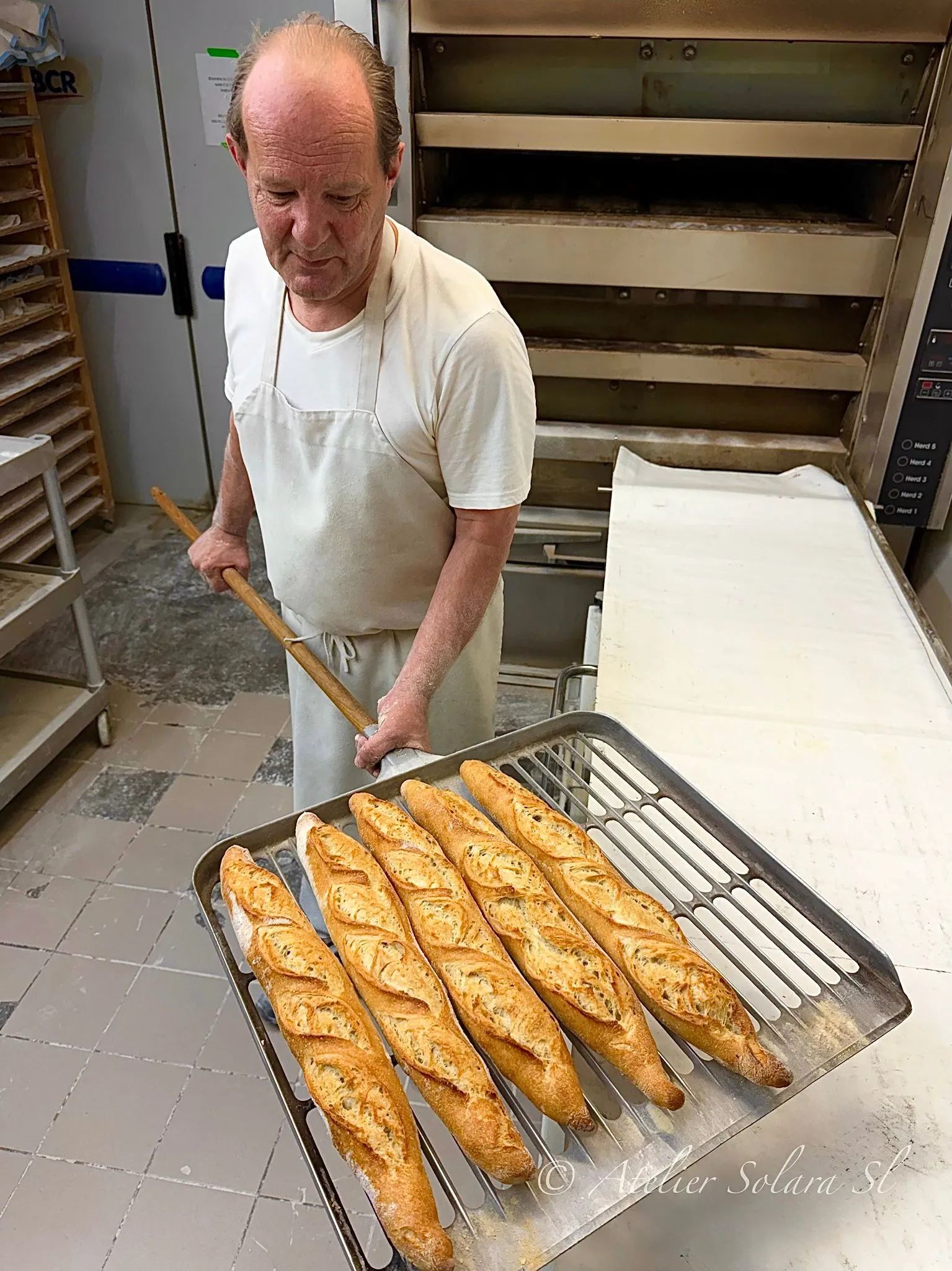 Thierry Goupil sort une plaque de baguettes du four