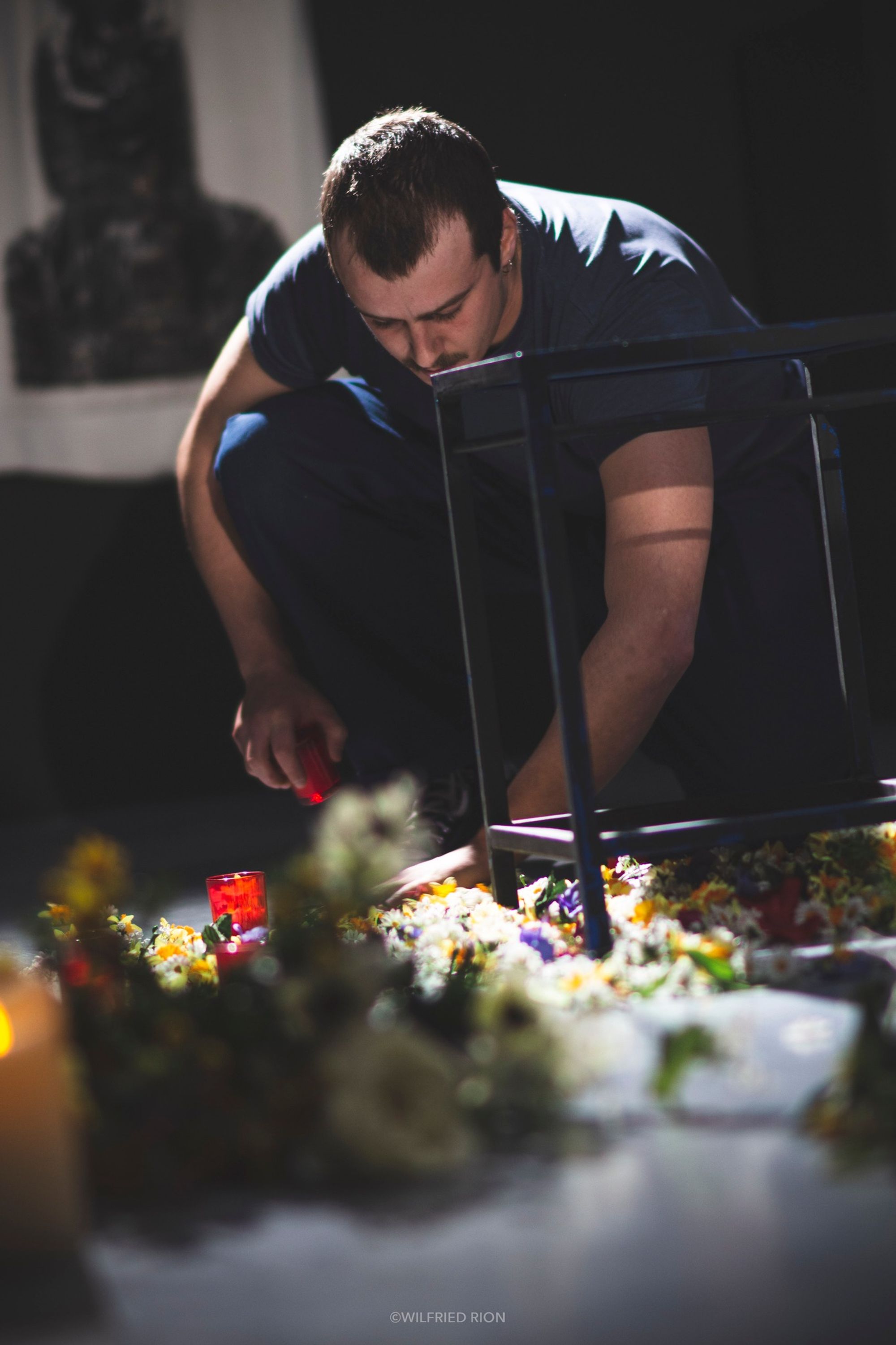 Un homme arrange un parterre de fleurs et de bougies