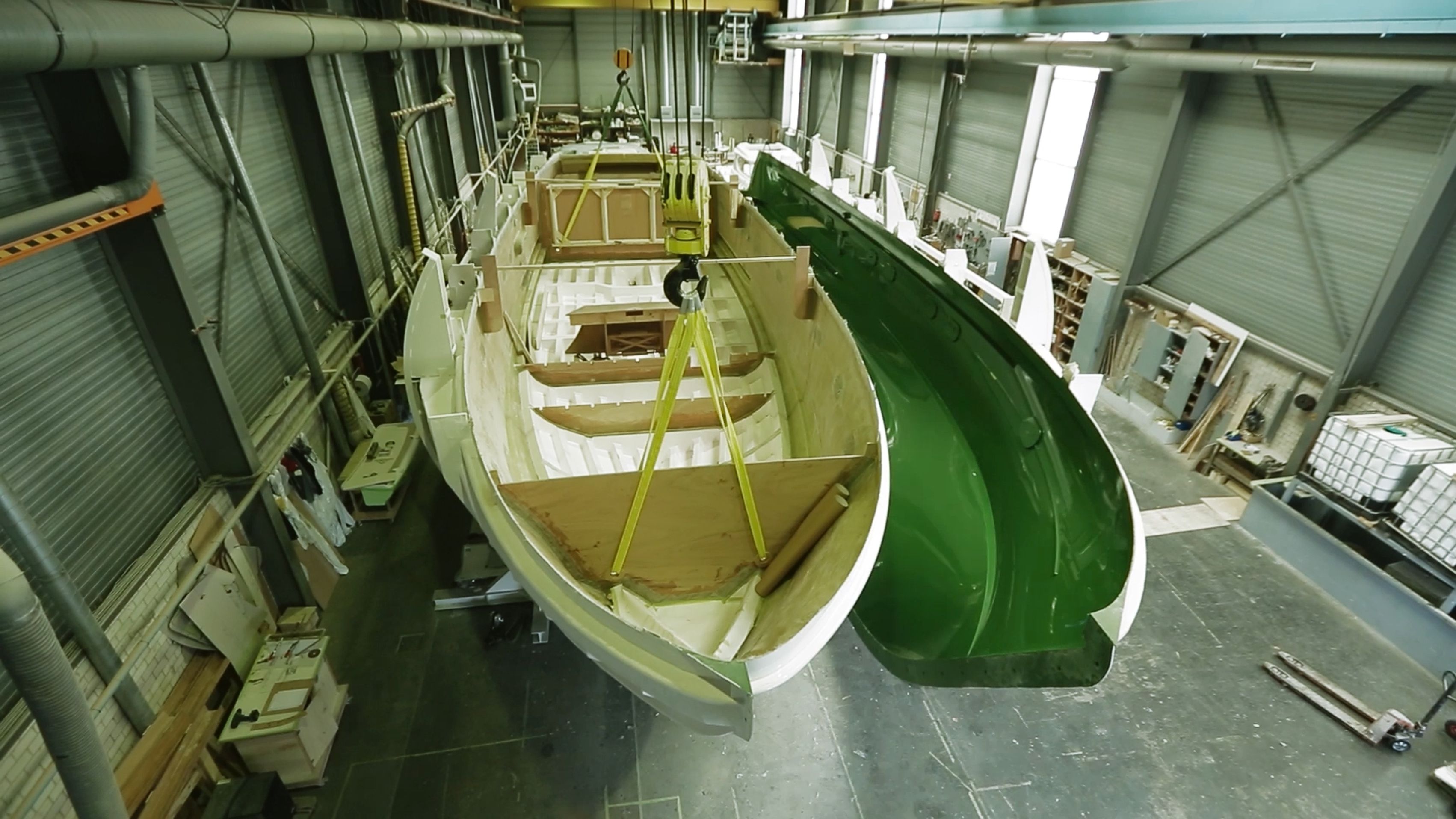 Een romp en zijn groene mal worden in de werkplaats van Elling met een kraan van elkaar getild