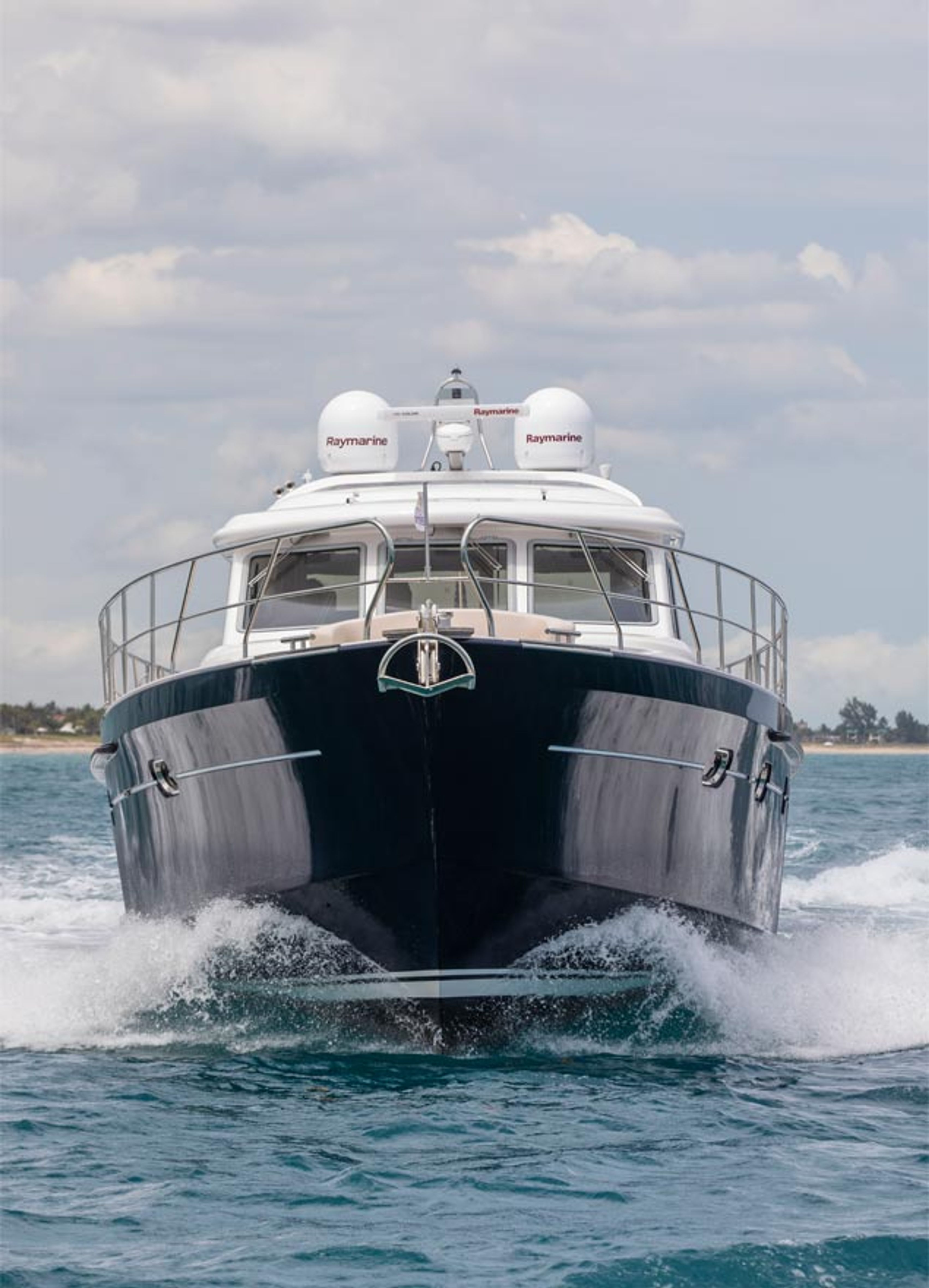 An Elling E6 seen bow-on, running towards the camera through blue water