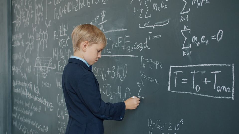 Child pointing to math work on paper explaining their solution process