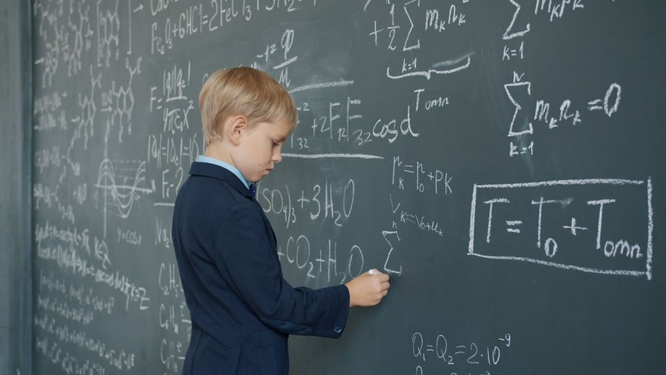 Child pointing to math work on paper explaining their solution process