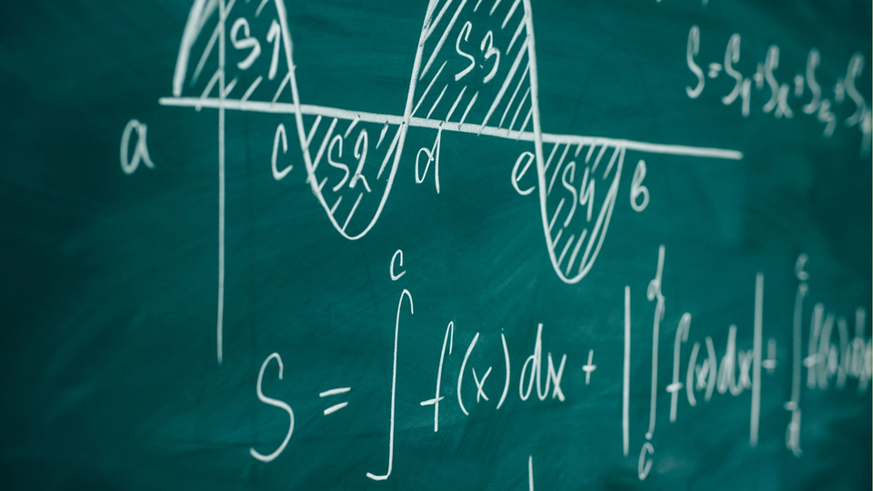 Chalkboard filled with calculus symbols and equations.