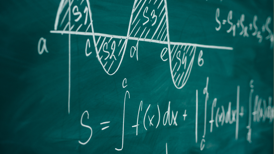 Chalkboard filled with calculus symbols and equations.