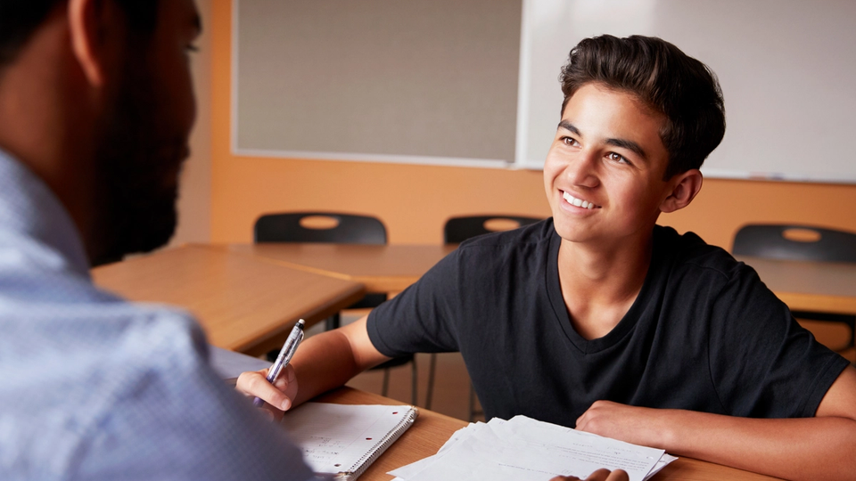 Boy working with a teacher on test prep after school.