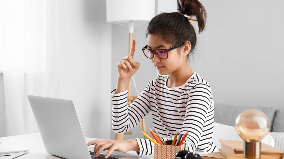 Girl on a computer participating in an online tutoring session.