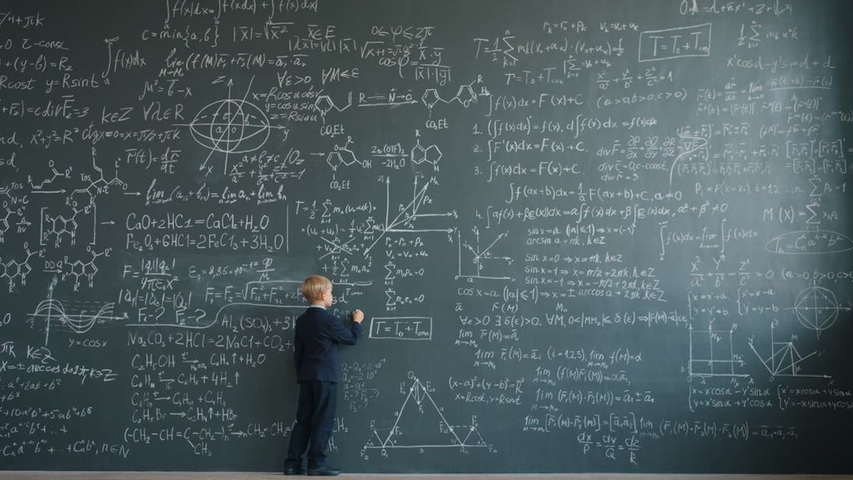 Happy child solving math problems with visual manipulatives and mathematical thinking tools on desk