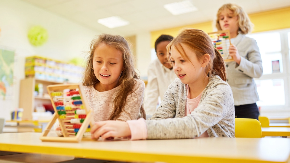 Kids in a classroom using rekenrek tools to learn math and develop critical thinking skills.