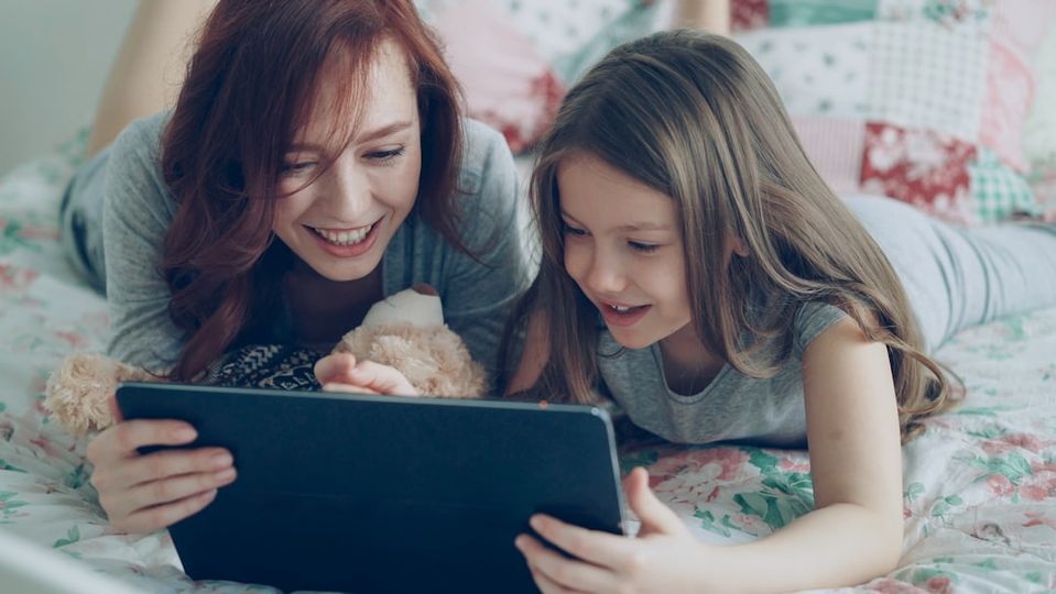 Parent and child using a tablet together for online math learning, showing modern educational technology