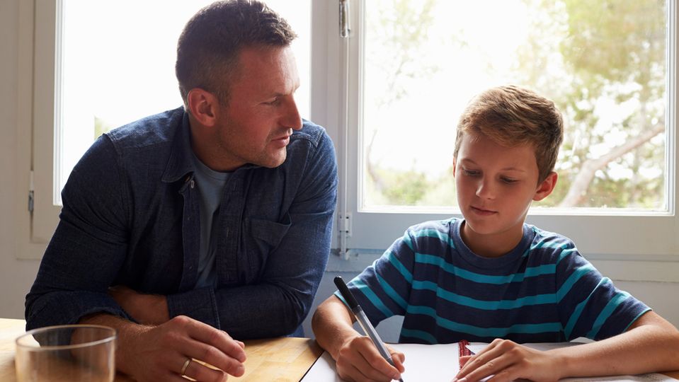 A father helps his son with homework.
