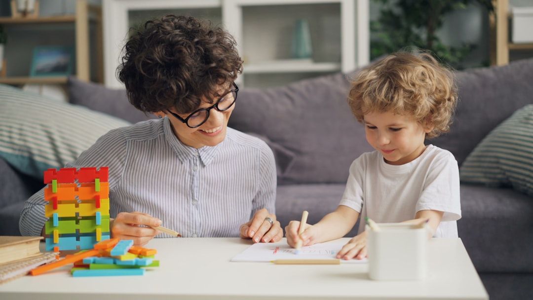 Parent sitting with child at table working on math homework together