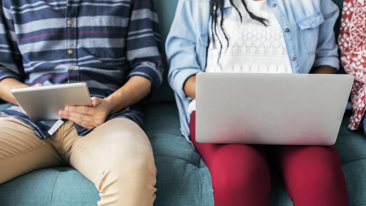 Cropped man and woman using electronic devices