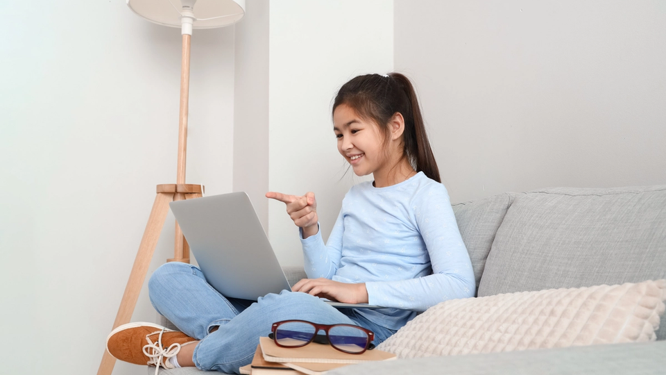 Young girl joining an online tutoring session on laptop, ready to learn and improve her math skills.
