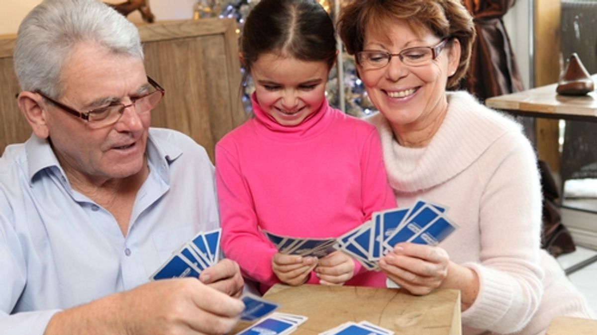 Girl playing cards with grandparents