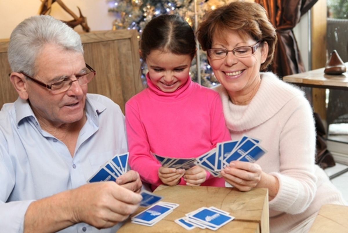Girl playing cards with grandparents