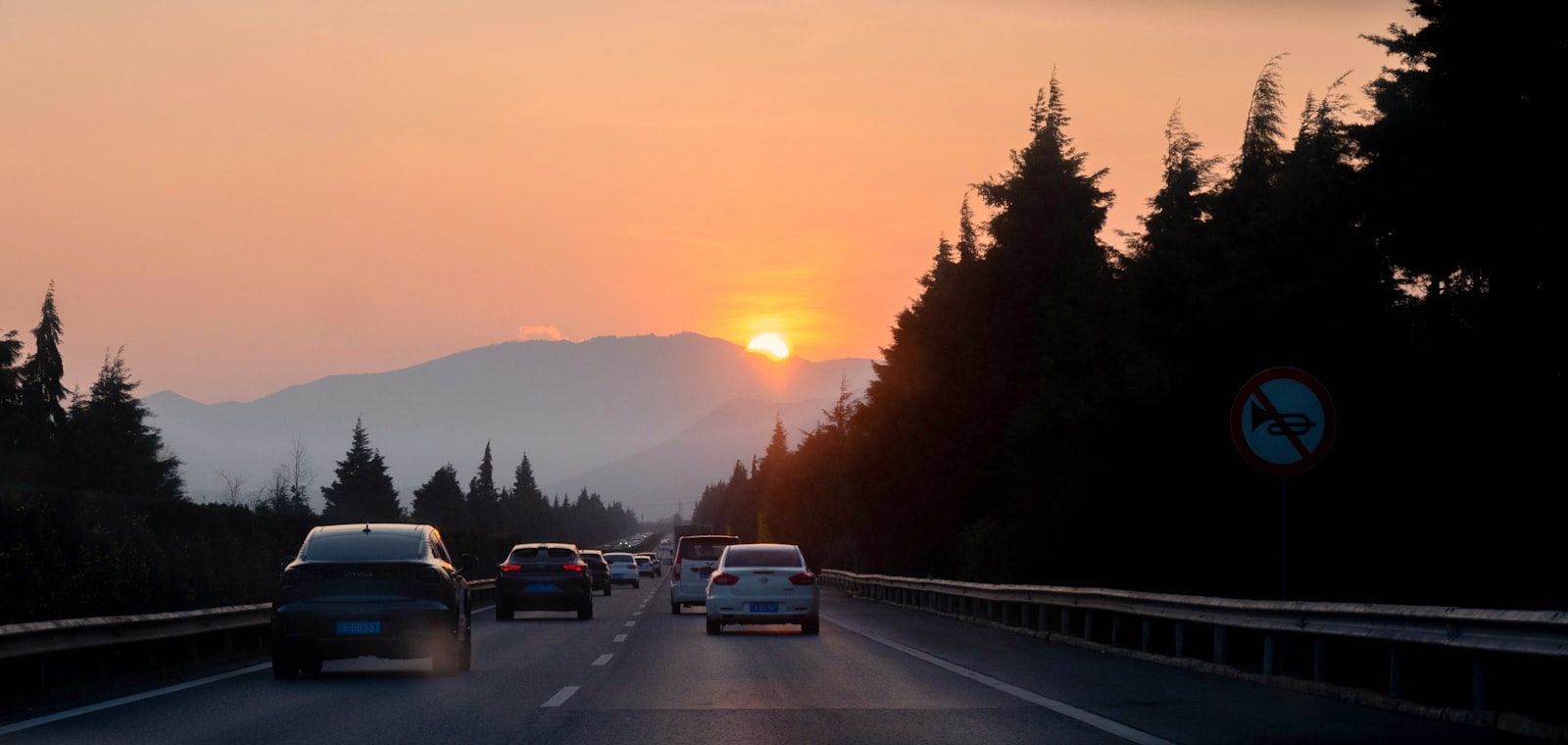 Cars traveling along a highway at sunset