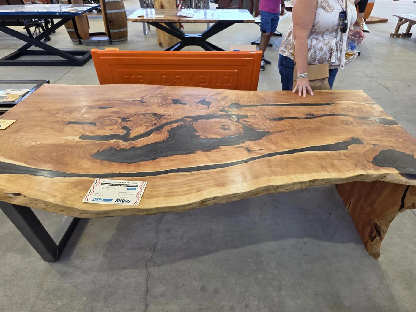 Student-built live-edge wood table with dark resin details at the Mid-State Fair industrial-arts exhibit