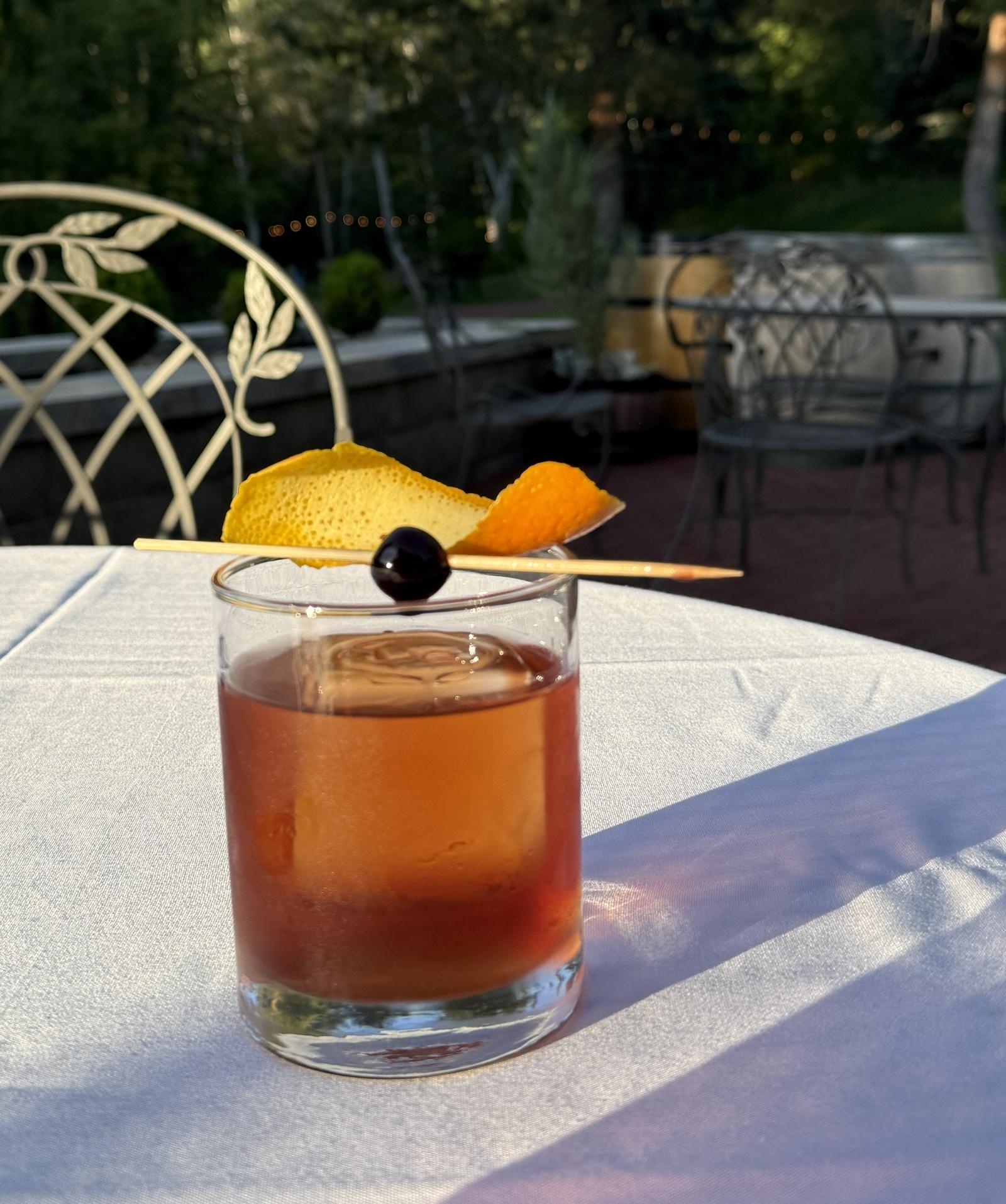 Amber drink served over ice in clear rocks glasses on an outdoor table