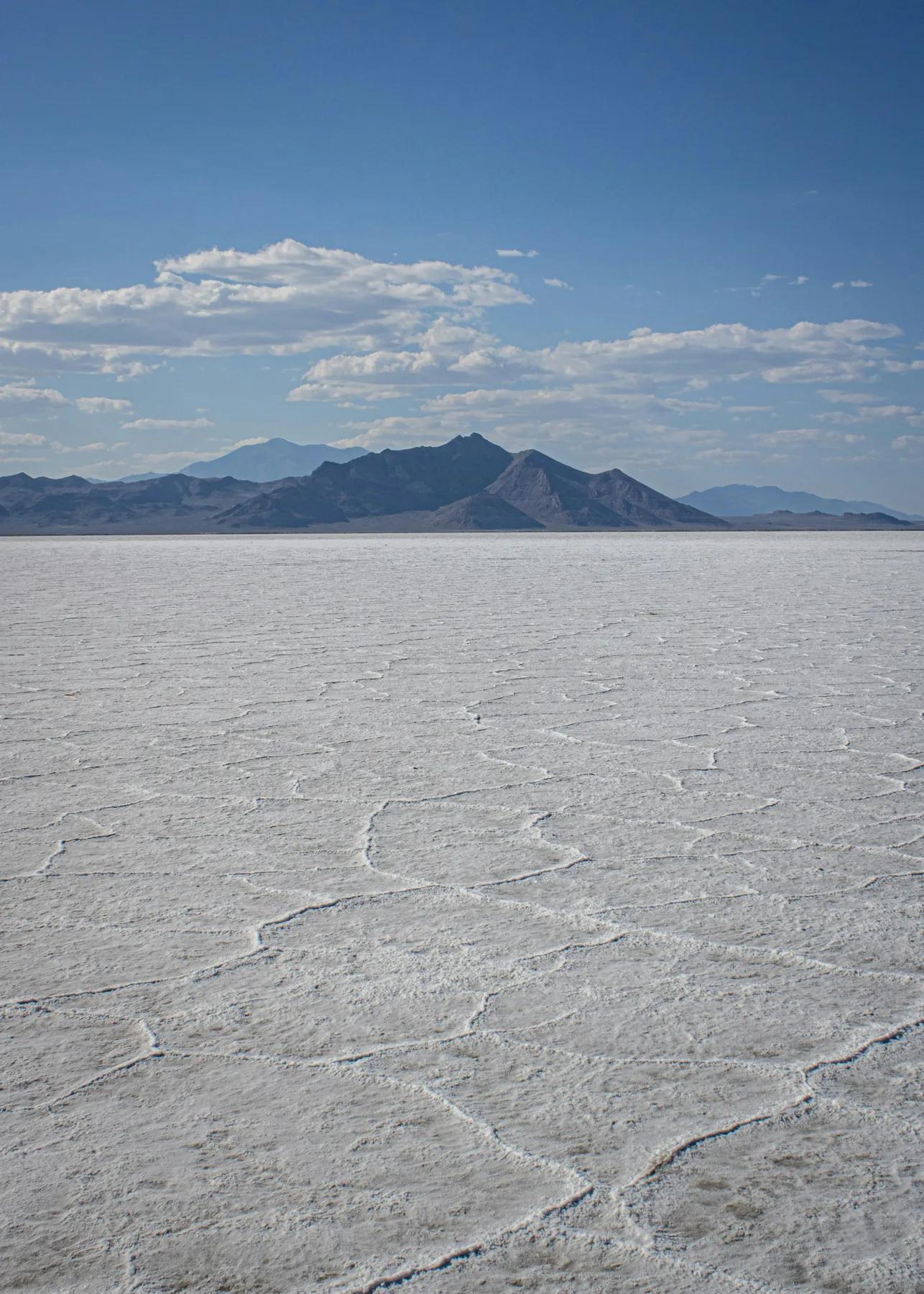 The white surface of the Bonneville Salt Flats stretching toward low blue mountains