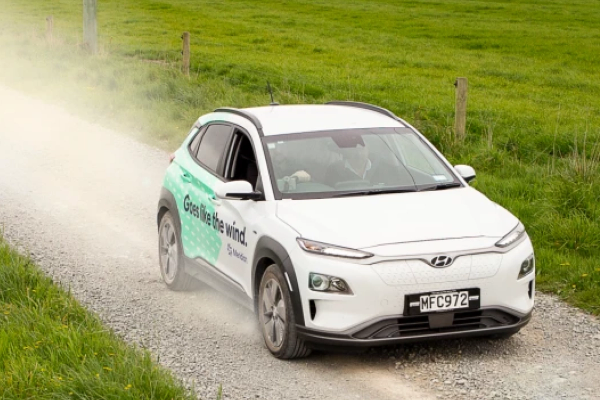 Meridian fleet electric vehicle driving on a dirt gravel road in rural NZ