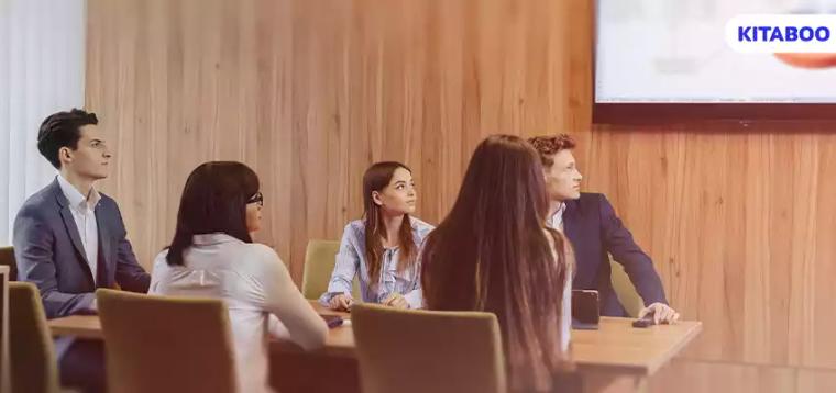 Large team of people is working at one table for laptops,