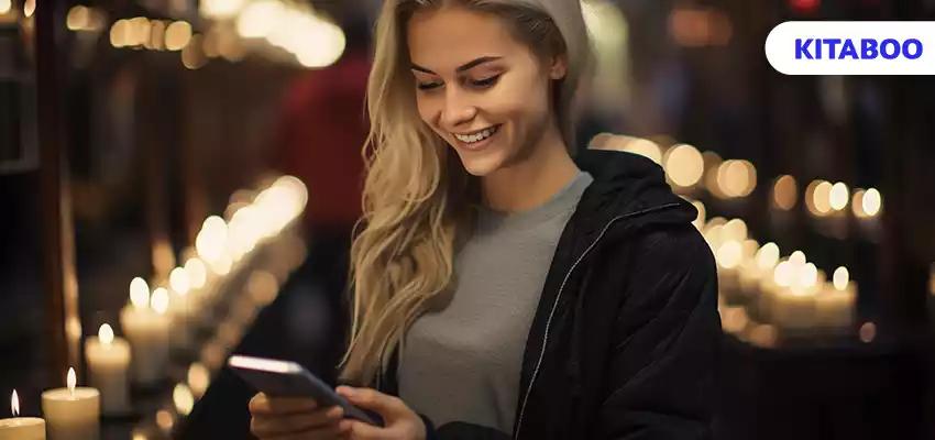Young woman smiling holding phone enjoying candlelit relaxation indoors generated by artificial intelligence blog