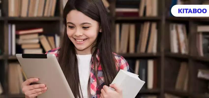 Portrait of young girl playing on tablet at the library