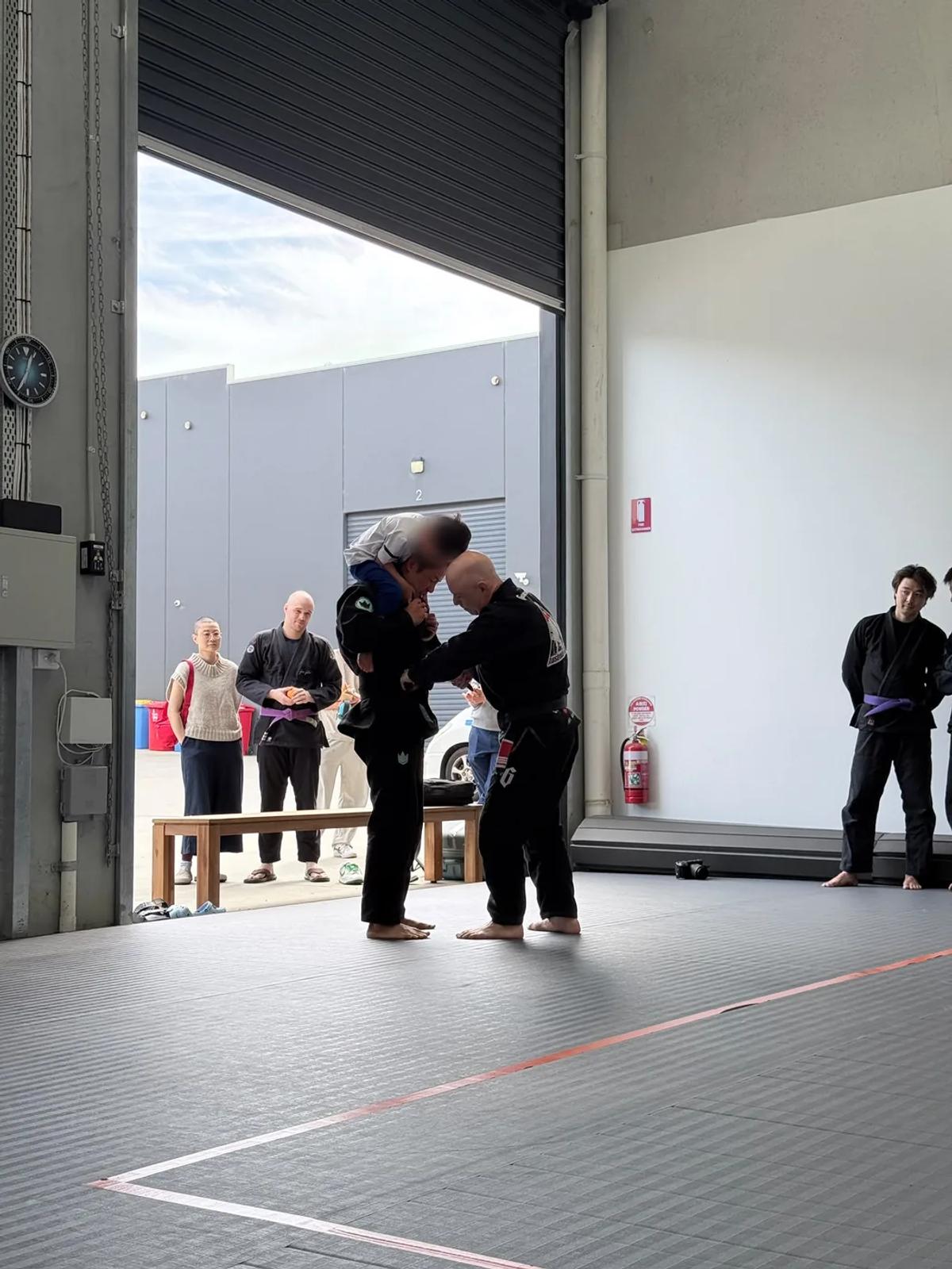 Two coaches greeting each other on the mats at the Mitcham academy on opening day