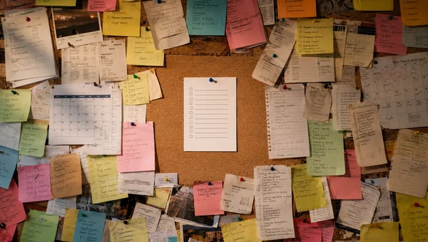 An overcrowded bulletin board filled with reminders and sticky notes surrounding one organized checklist, representing finding clarity when everything feels important.