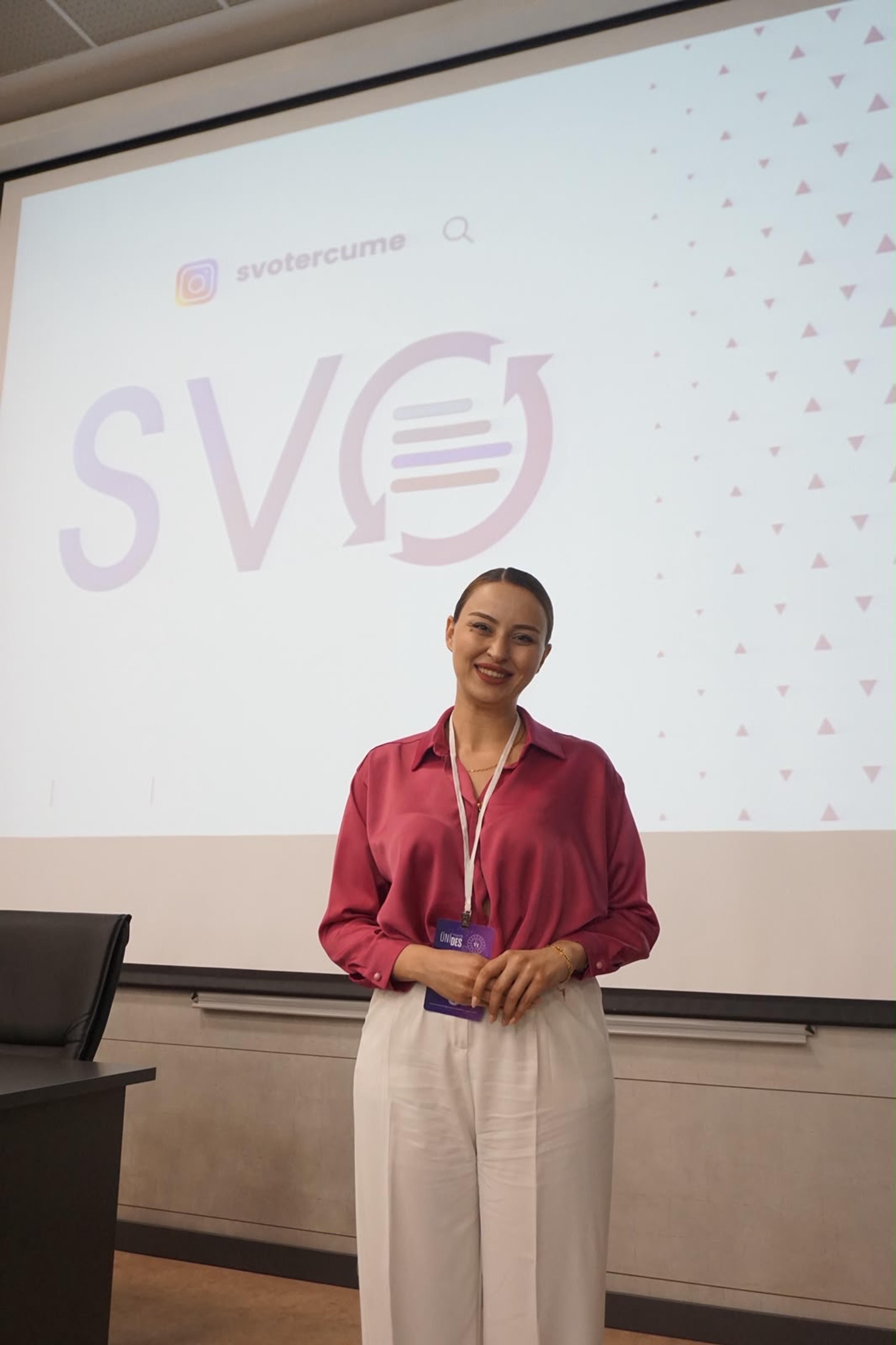 Ceren Höbek, arkasındaki perdede SVO Tercüme logosu ve Instagram adresiyle, bir sunumda