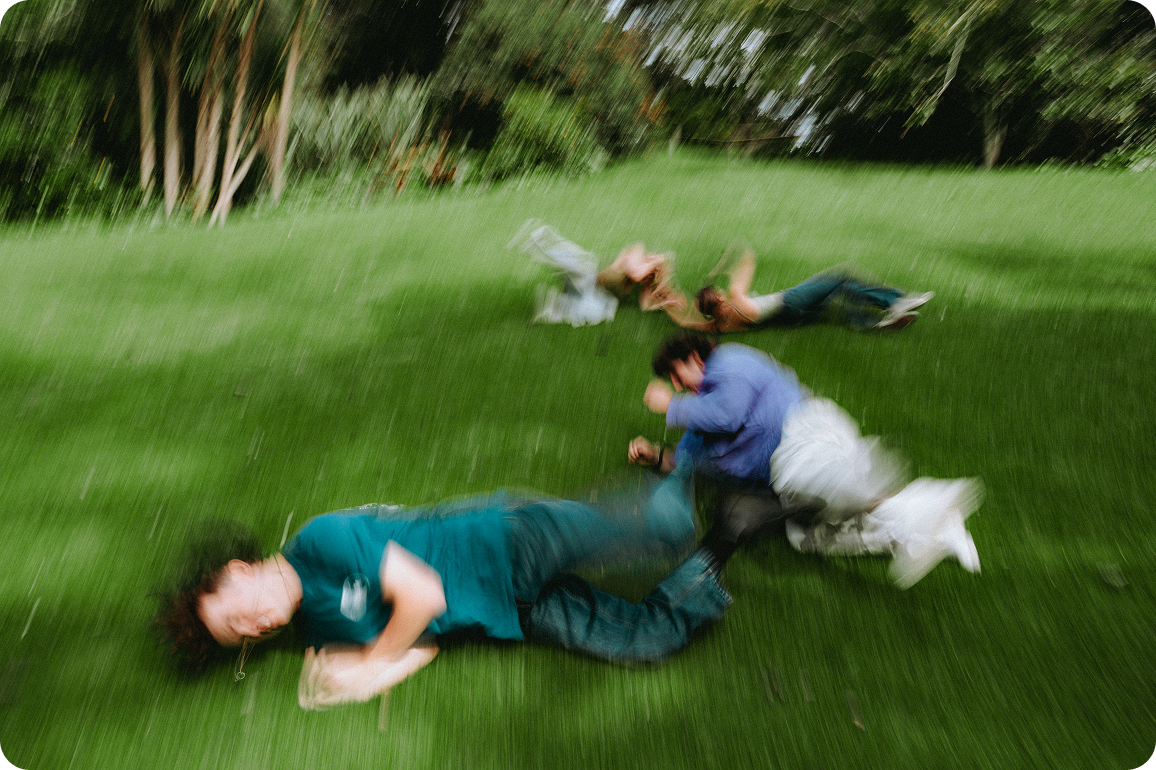 Group of people running across a grassy field, depicted with strong motion blur.