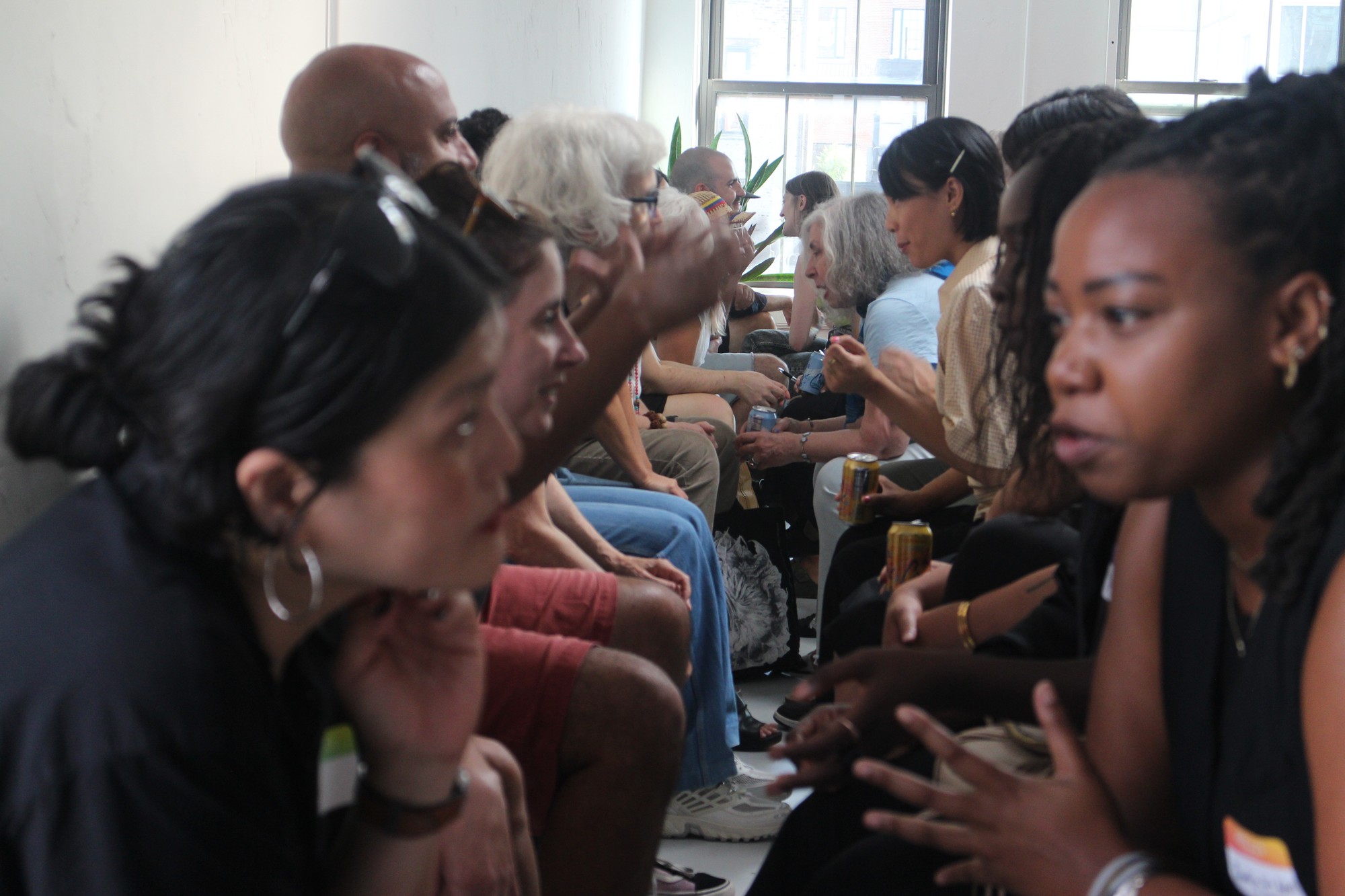 Two rows of research participants sit facing each other, leaning in as they engage in conversation.