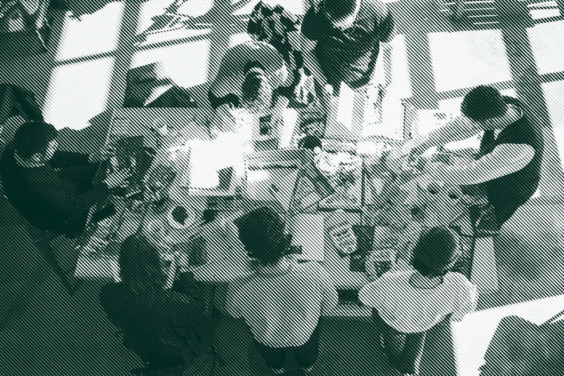 A birdseye view of a table covered with magazines and collage materials and surrounded by seven people making zines together.