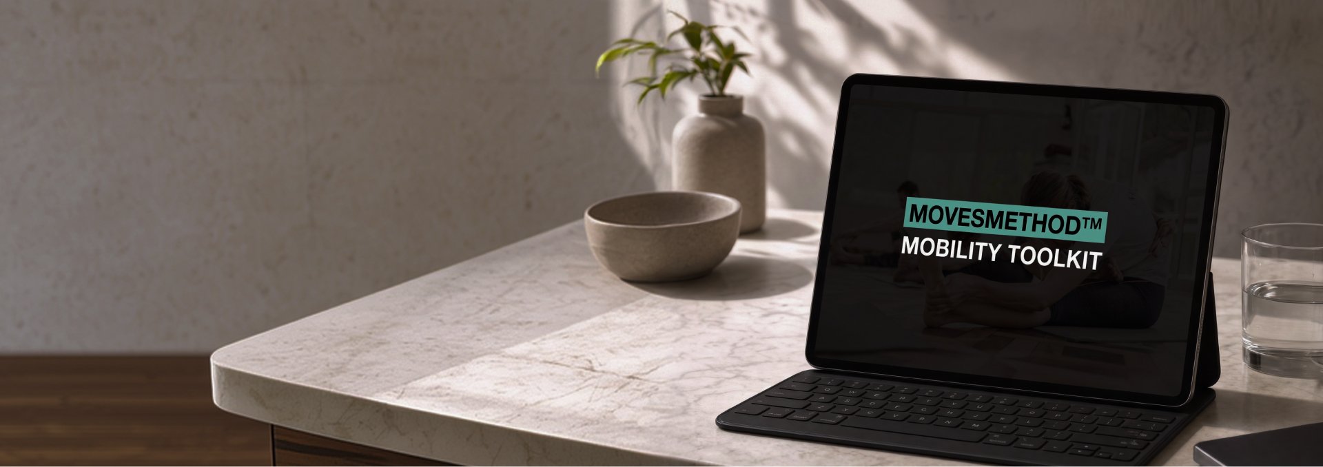 Tablet displaying "MOVESMETHOD™ MOBILITY TOOLKIT" on a light-colored table with a plant.