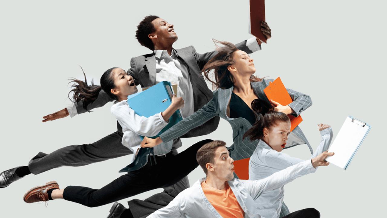 Diverse business people energetically leaping with folders and clipboards against a light background.