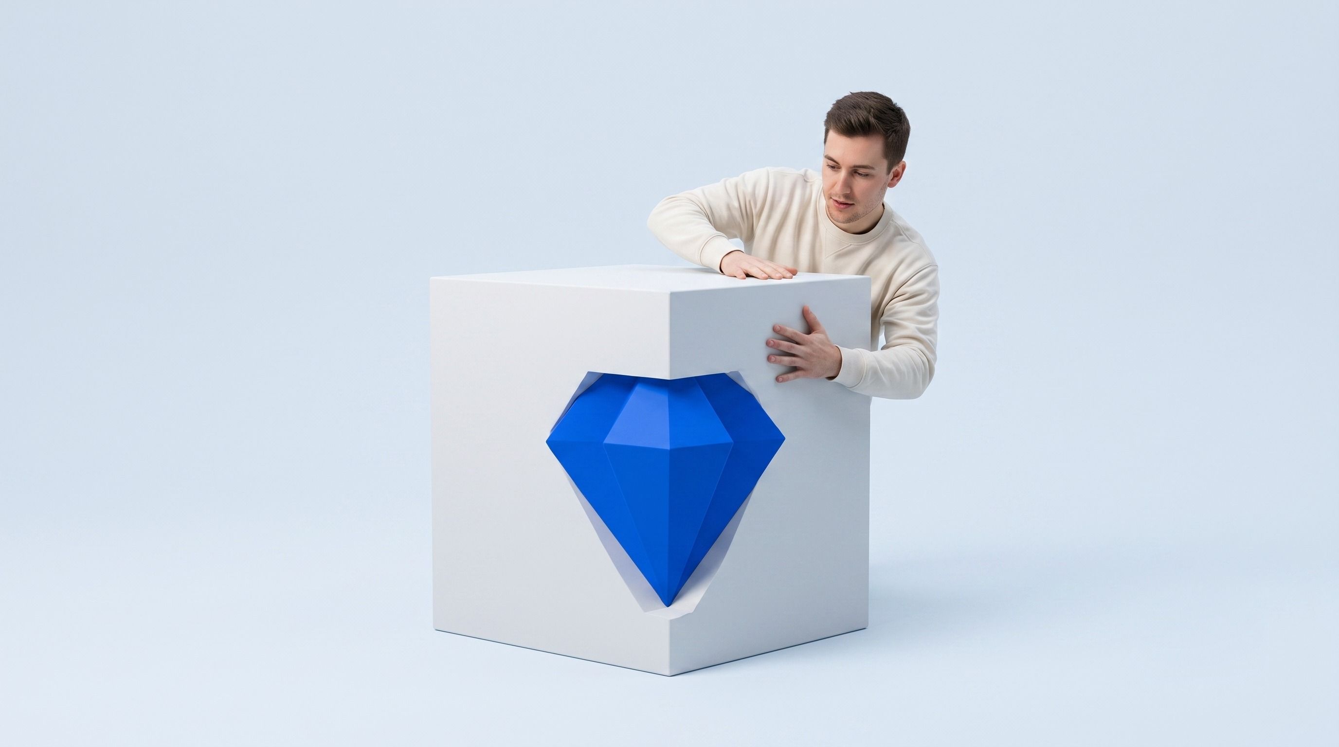 Man revealing a blue diamond cut into a white cube.
