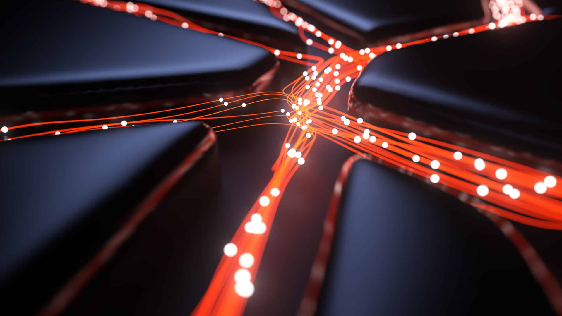 Glowing orange fiber optic lines with white light dots flowing through dark, abstract structures.