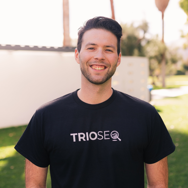 Smiling man wearing a black TRIOSEQ t-shirt.