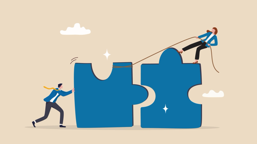 A man pushes while a woman pulls two blue puzzle pieces together, symbolizing teamwork.