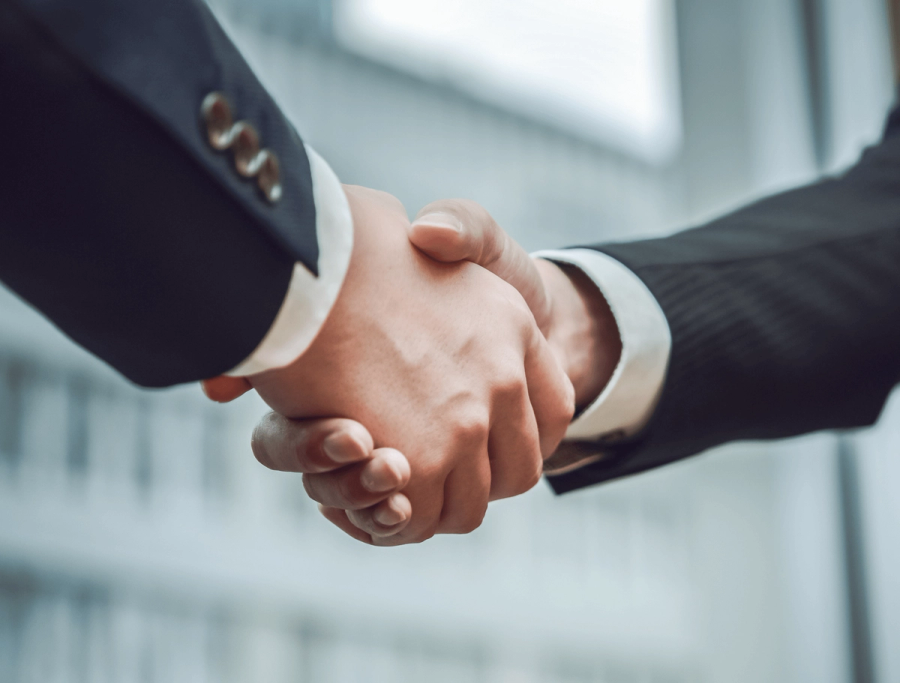 Two people in suits shaking hands.