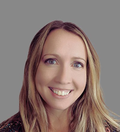Headshot of a smiling woman with long blonde hair and blue eyes against a gray background.
