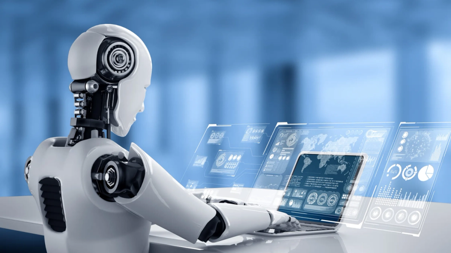A white humanoid robot types on a laptop with holographic data displays.