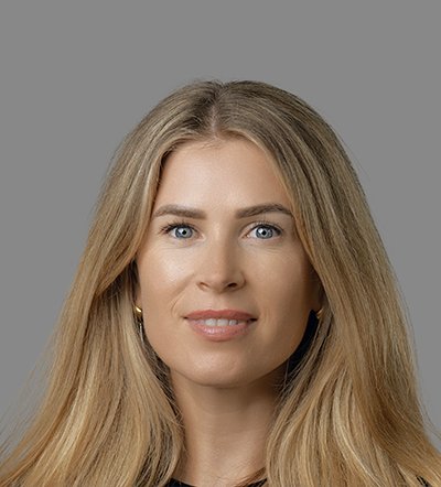 Headshot of a smiling woman with blonde hair and blue eyes.