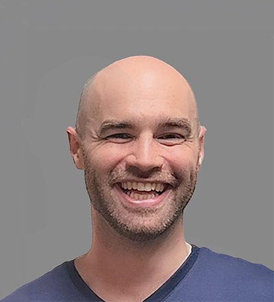 Headshot of a smiling bald man with a beard.