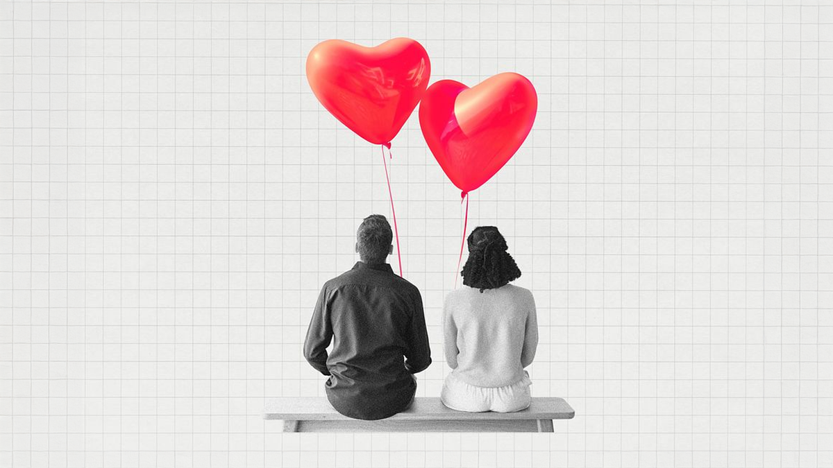 Grayscale man and woman sit on a bench from behind, with two vibrant red heart balloons above them against a grid background.